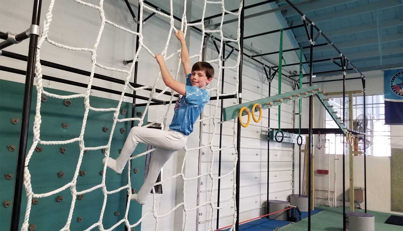A student climbing the GymNinja tower